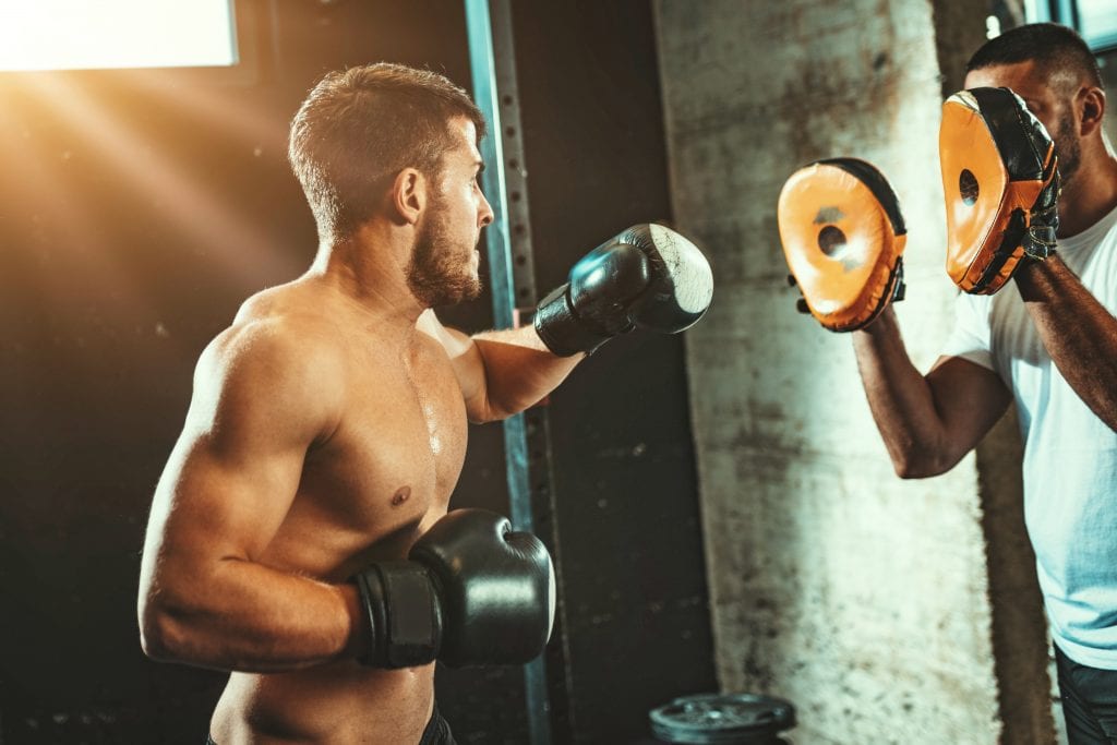 two men with boxing gloves and pads boxing